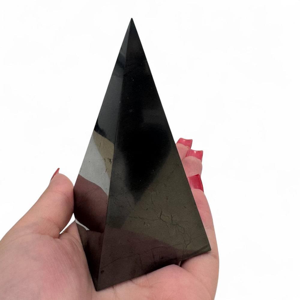 5cm Shungite Nubian Pyramid held in hand – polished black crystal pyramid for EMF protection and meditation.