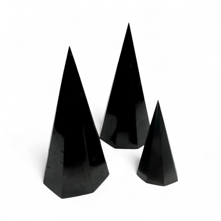 Three polished Shungite octagonal pyramids in different sizes (50mm, 10cm, and 12cm), natural black crystal energy tools for EMF protection, grounding, and meditation.