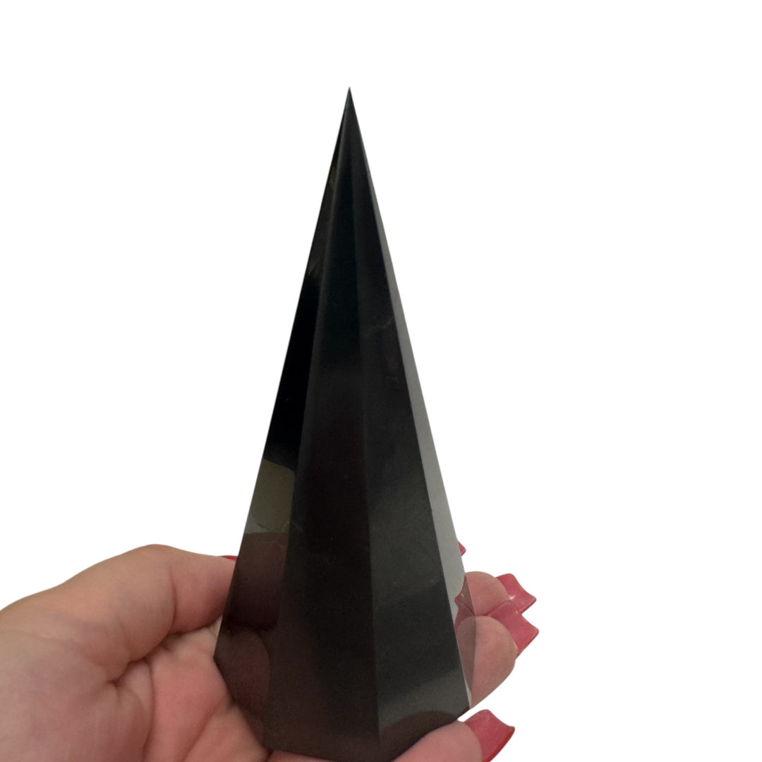 12cm octagonal shungite pyramid held in hand – polished black crystal for EMF protection, meditation, and grounding energy.