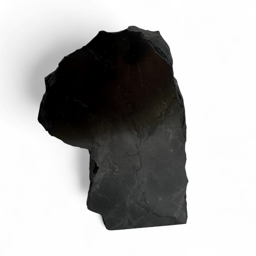 Large one-face polished shungite stone with glossy black surface and natural rough edges, used for EMF protection and energy cleansing.