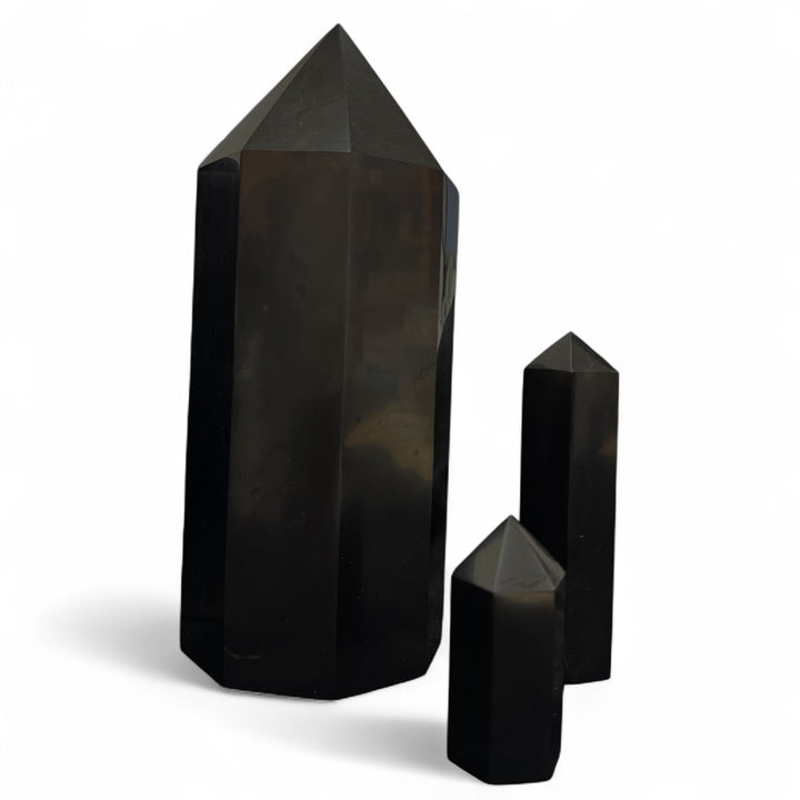 Set of three polished shungite towers in 5cm, 10cm, and 20cm sizes, displayed side by side for size comparison.