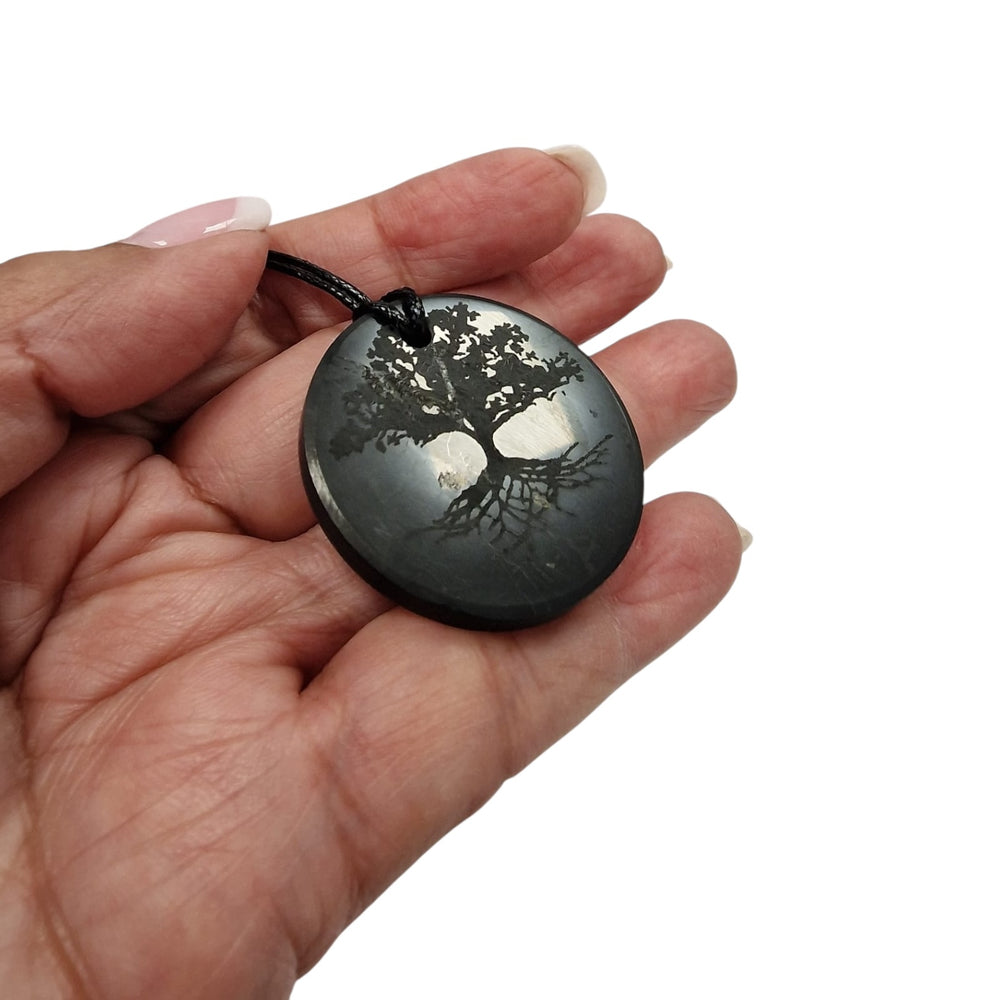 Tree of Life Shungite pendant on white background, symbolic crystal necklace for balance and protection