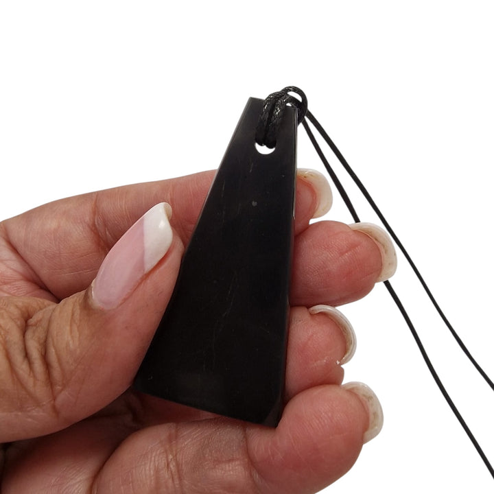 Trapezoid Shungite pendant with black cotton cord on hand, vegan-safe grounding jewellery for EMF protection