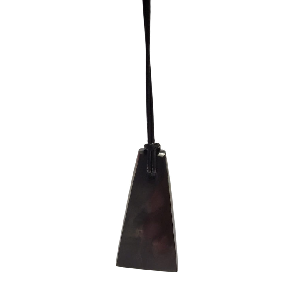 Close-up of trapezoid Shungite pendant showing smooth finish and black cotton cord