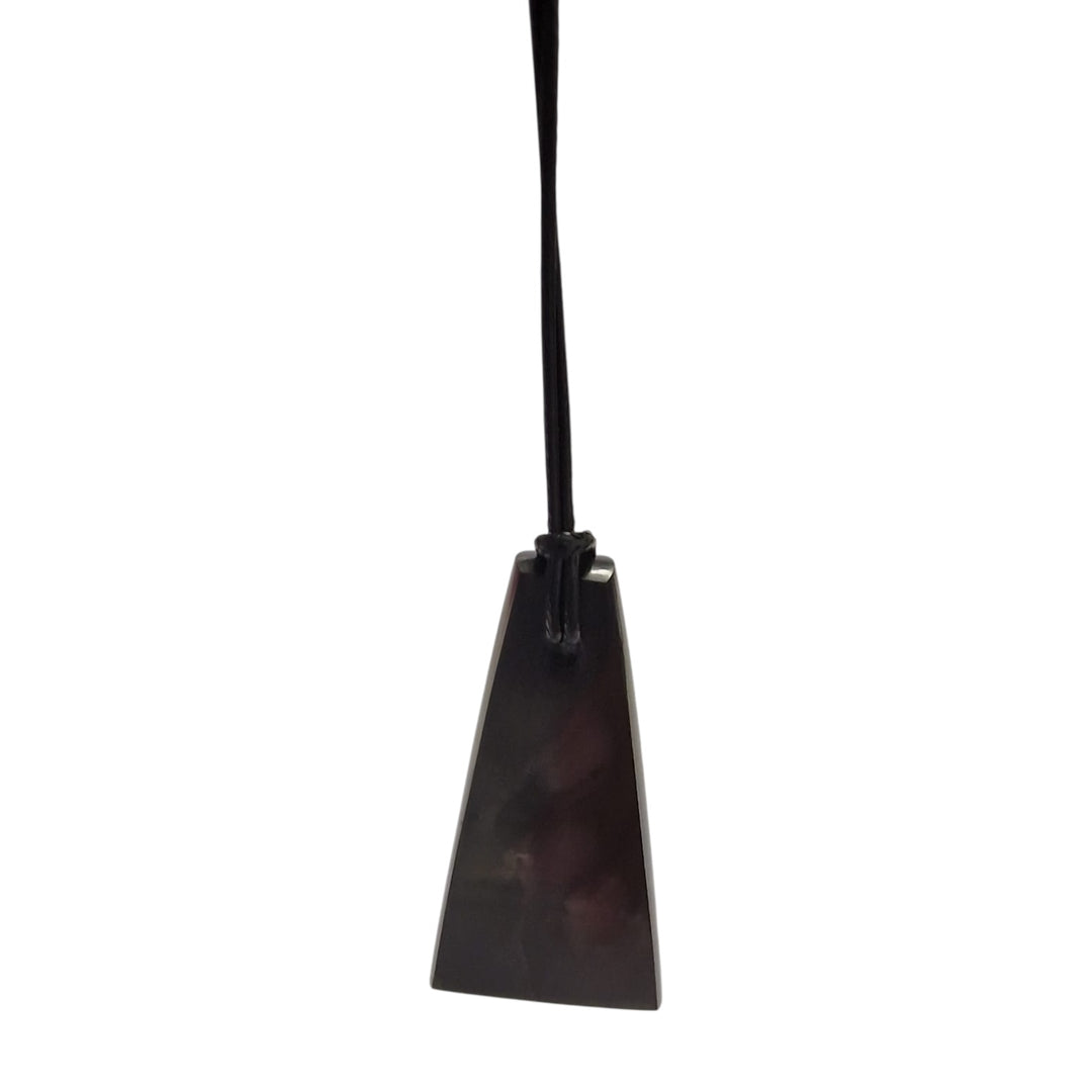 Close-up of trapezoid Shungite pendant showing smooth finish and black cotton cord