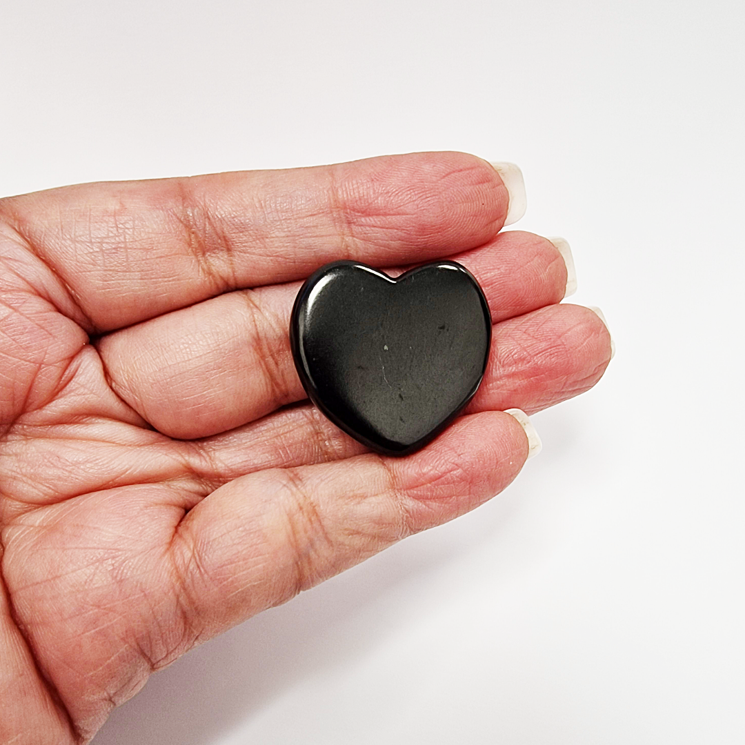 Shungite 30mm heart in soft natural light, representing emotional healing and grounding