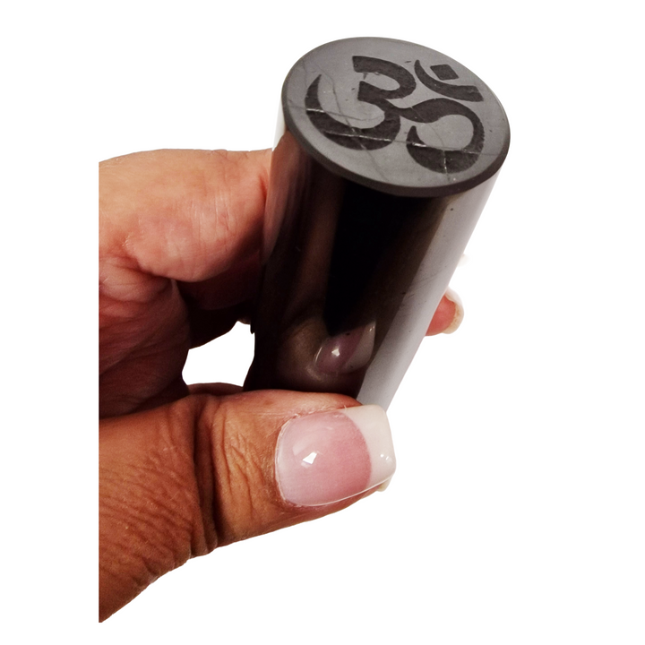 Shungite Cylinder 10cm with Yin Yang and Ohm engravings on hand for size reference, grounding and EMF protection
