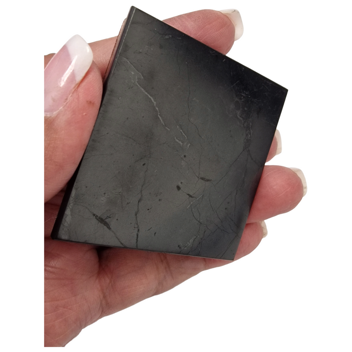 Minimalistic workspace with Shungite square slice placed underneath laptop for discreet EMF protection