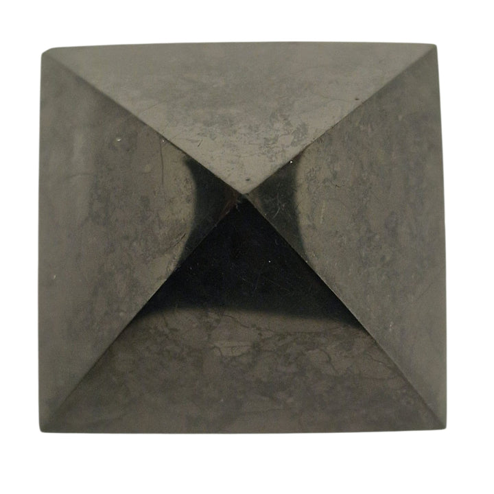 Side view of Shungite 40mm Pyramid on white background, grounding stone for EMF shielding