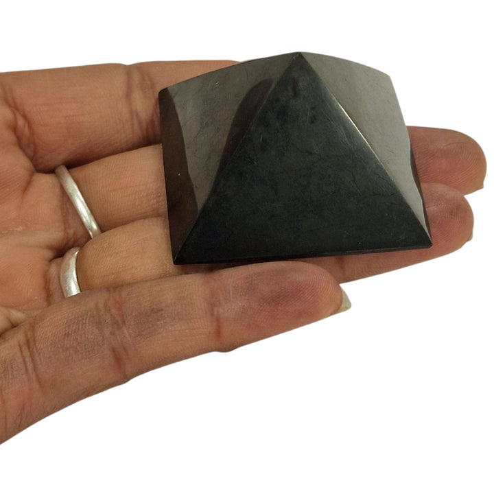 Shungite 40mm Pyramid on hand for size reference, grounding and EMF protection crystal