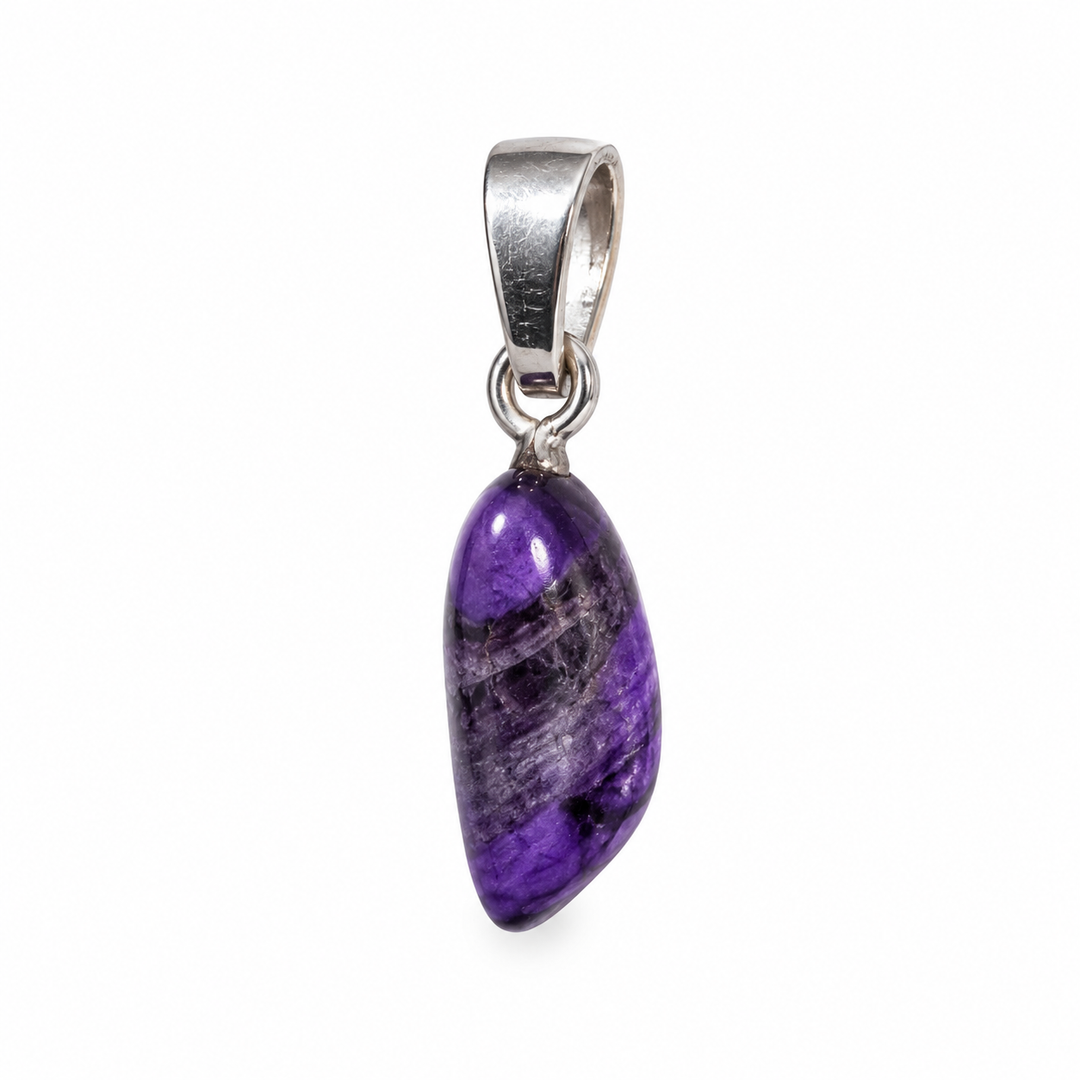 GeoFossils Sugilite pendant photographed from the side, highlighting the gemstone's natural thickness, curved polished surface and sterling silver fitting.