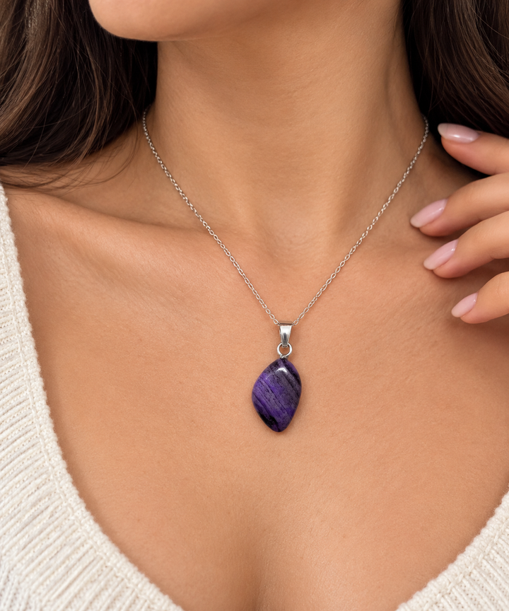 GeoFossils Sugilite pendant worn on a model with a delicate silver chain, showcasing the rich purple gemstone, natural dark veining and petite jewellery proportions.