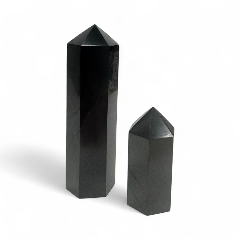 Two polished shungite towers, 5cm and 10cm sizes, displayed side by side for size comparison.