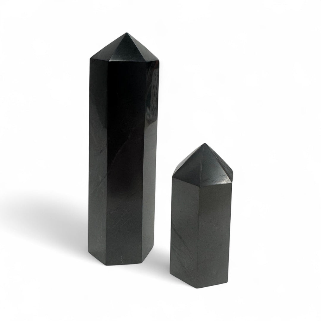 Two polished shungite towers, 5cm and 10cm sizes, displayed side by side for size comparison.