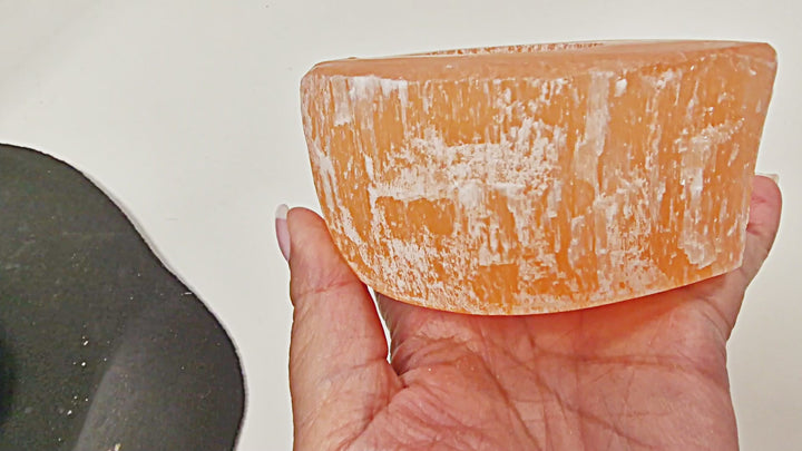 17-second video of a Peach Selenite Heart Tea Light Holder being rotated in hand, showing its carved heart shape, polished surfaces, and warm orange glow. 