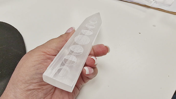 18-second video of a Selenite Moon Phase Blade – Engraved Polished Wand being held and rotated to display the engraved moon phases, polished sides, and pointed blade-like tip from all angles.