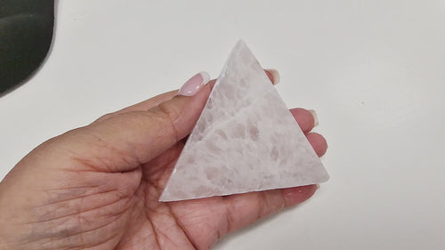 GeoFossils 13-second video of a Selenite Triangle Charging Disc 80mm being held and rotated in hand, showing its polished triangular shape, luminous glow, and natural striations from all angles.