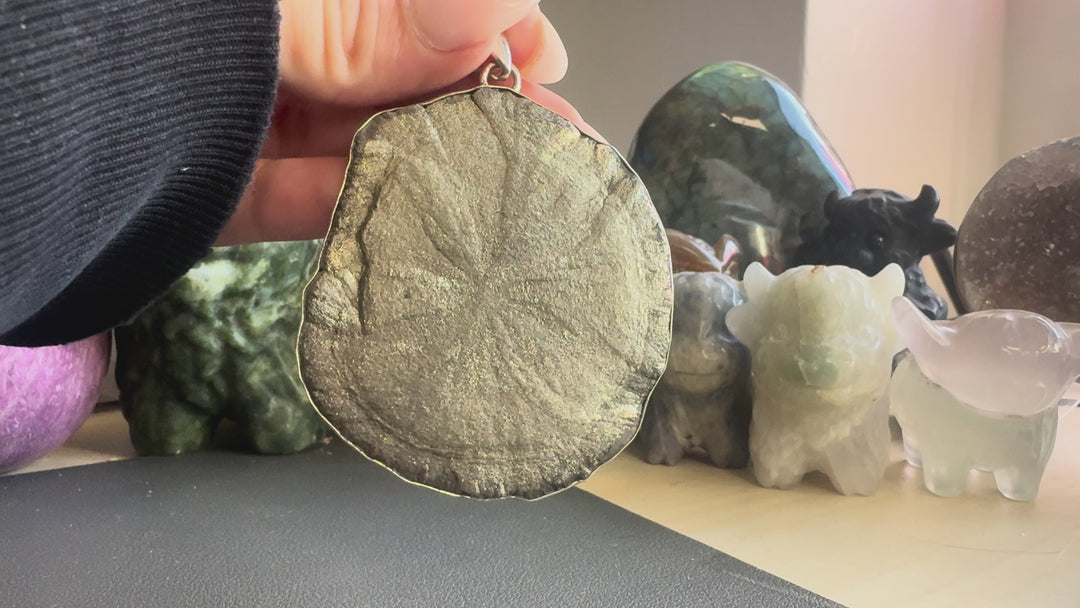 Video of a natural Pyrite Sun pendant in a sterling silver setting, showing its metallic golden-grey colour, natural texture and details from multiple angles.