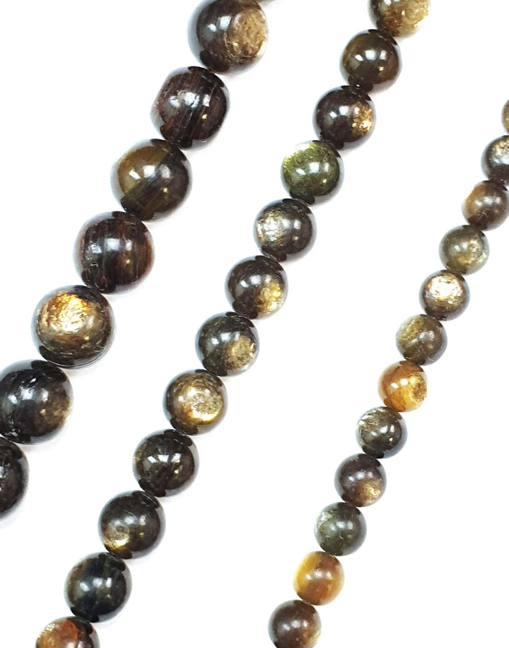 Gold Mica round beads on a white background