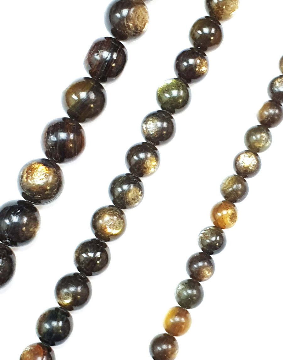Gold Mica round beads on a white background